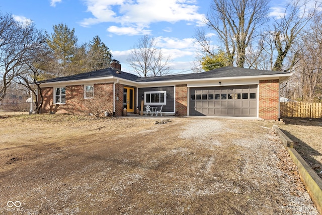 ranch-style home featuring a garage, brick siding, fence, driveway, and a chimney