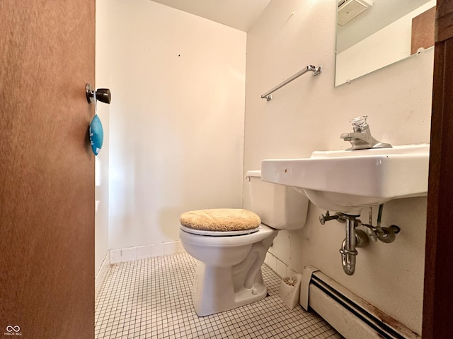 half bath with tile patterned floors, a baseboard radiator, baseboards, and toilet