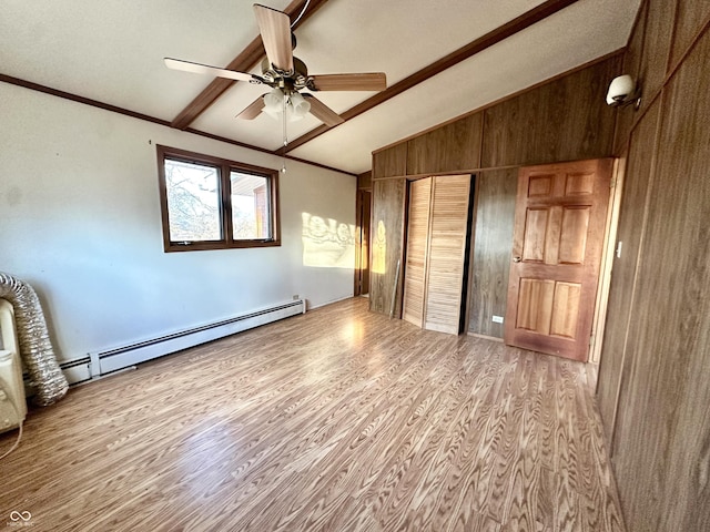 unfurnished bedroom with wood finished floors, a baseboard radiator, vaulted ceiling with beams, a closet, and crown molding