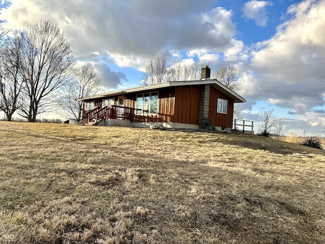 exterior space featuring a chimney and a front yard