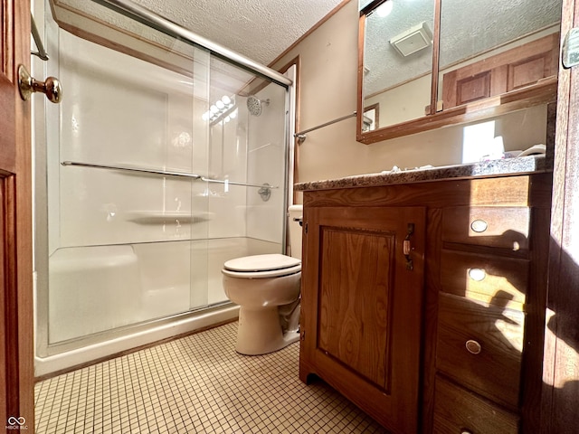 bathroom featuring vanity, toilet, a shower stall, and a textured ceiling