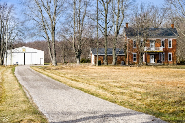 view of road with driveway and a pole building