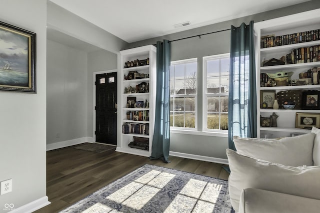 foyer entrance with baseboards, visible vents, and dark wood-type flooring