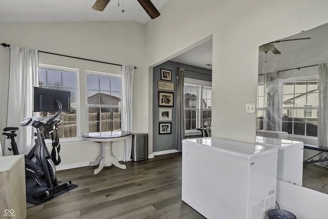 interior space with dark wood-type flooring, lofted ceiling, ceiling fan, and baseboards