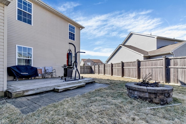 view of yard featuring a fenced backyard, a fire pit, and a wooden deck