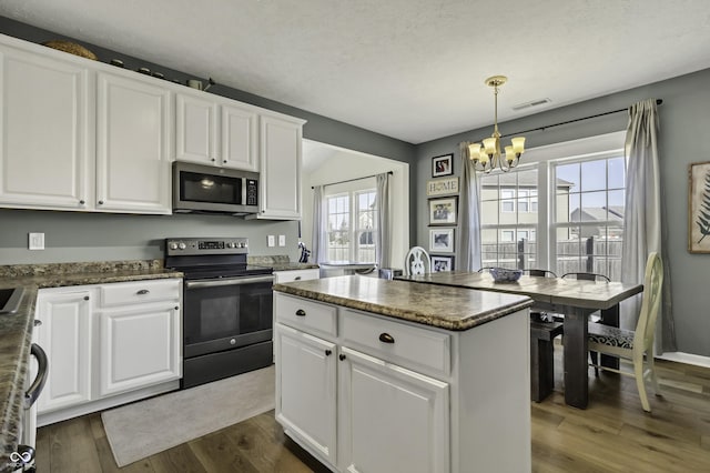 kitchen with dark wood-style floors, visible vents, appliances with stainless steel finishes, white cabinetry, and a chandelier