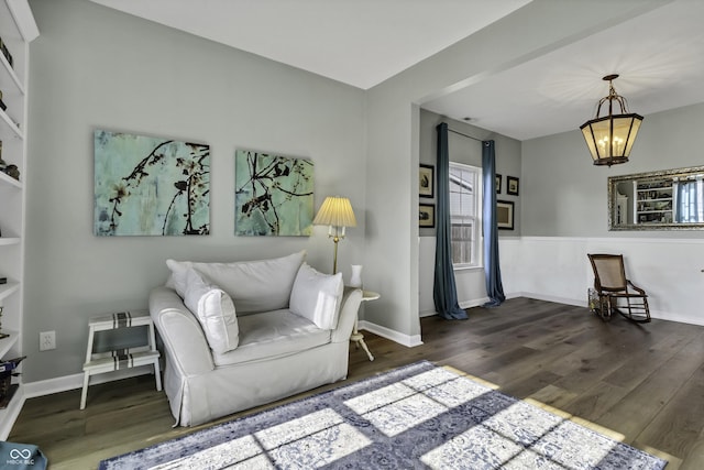 living room with dark wood-style floors, baseboards, and an inviting chandelier