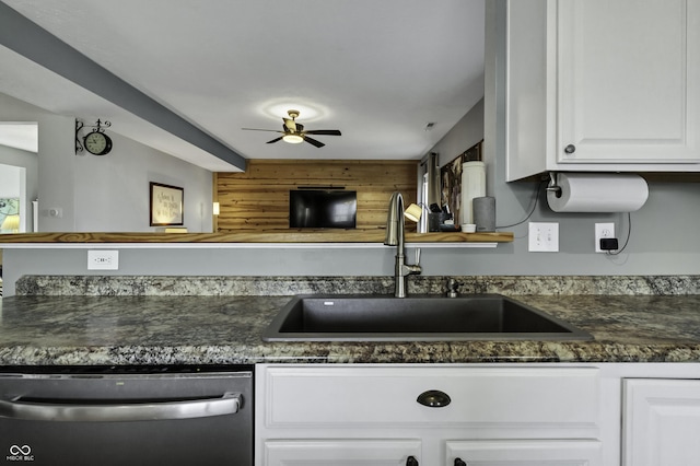 kitchen with dishwasher, dark countertops, ceiling fan, white cabinetry, and a sink