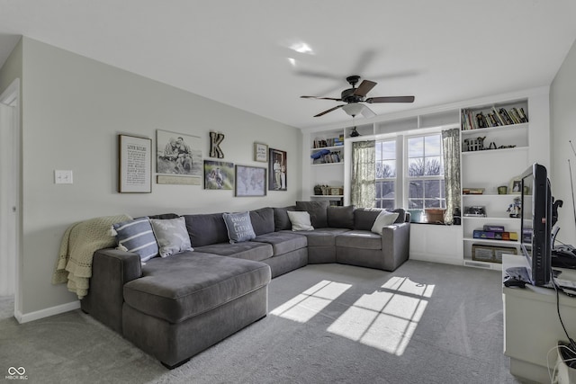 carpeted living area with ceiling fan