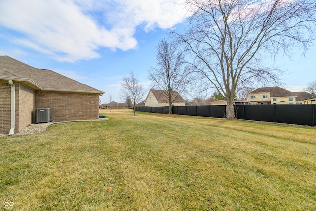 view of yard with fence and central AC