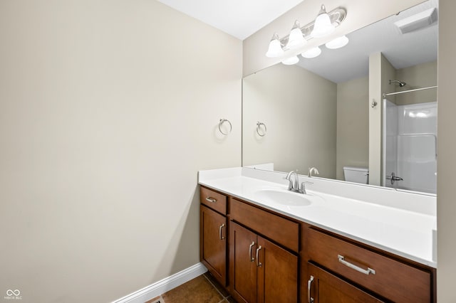 bathroom featuring toilet, tile patterned flooring, walk in shower, and vanity