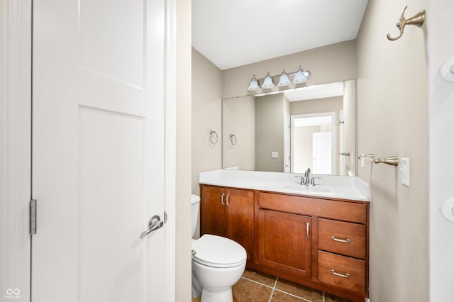 half bathroom with toilet, vanity, and tile patterned floors