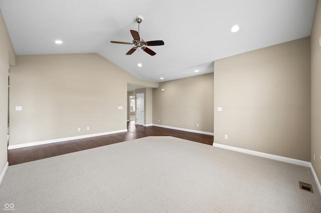 empty room featuring lofted ceiling, dark carpet, visible vents, and recessed lighting