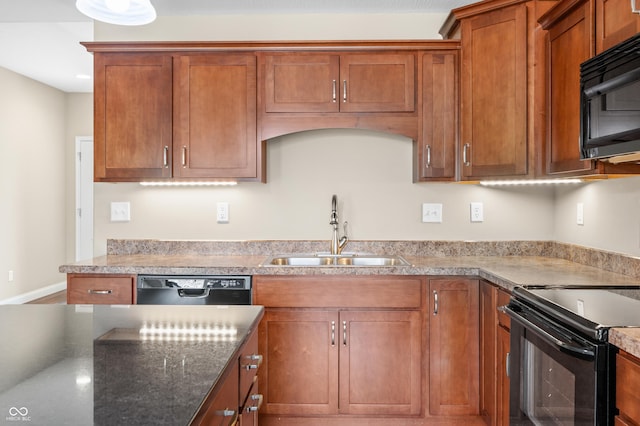 kitchen featuring black appliances, baseboards, brown cabinets, and a sink