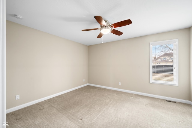 unfurnished room with light carpet, ceiling fan, visible vents, and baseboards