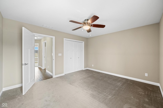 unfurnished bedroom with ceiling fan, carpet floors, visible vents, baseboards, and a closet