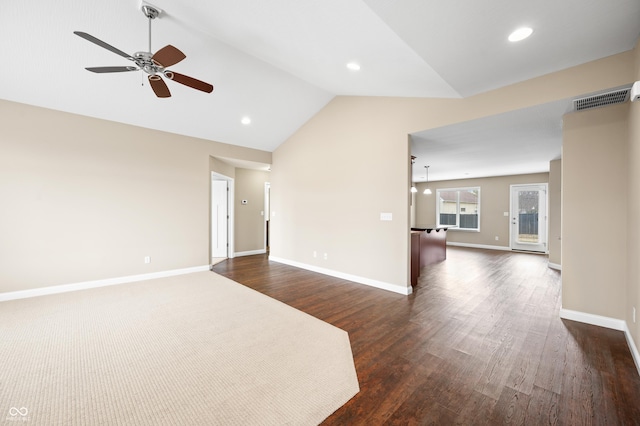 spare room with dark wood-style floors, lofted ceiling, visible vents, a ceiling fan, and baseboards