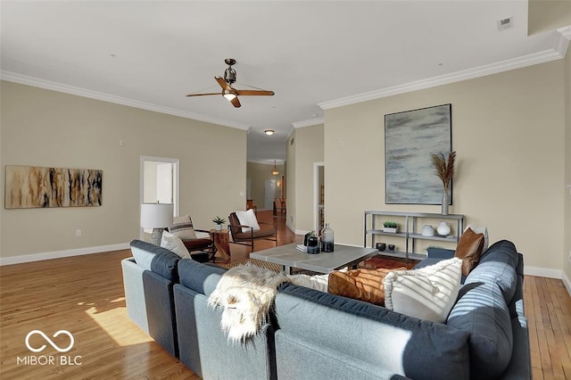 living room featuring hardwood / wood-style flooring, visible vents, a ceiling fan, baseboards, and crown molding