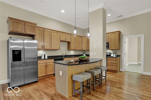 kitchen with ornamental molding, stainless steel refrigerator with ice dispenser, a kitchen breakfast bar, and light wood finished floors