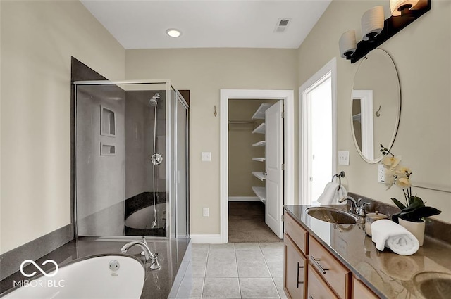 full bath featuring a garden tub, tile patterned flooring, a sink, visible vents, and a stall shower