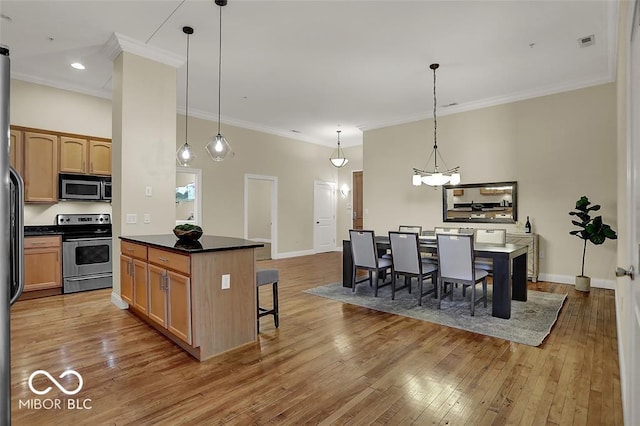 kitchen with stainless steel appliances, dark countertops, hardwood / wood-style floors, and a kitchen bar