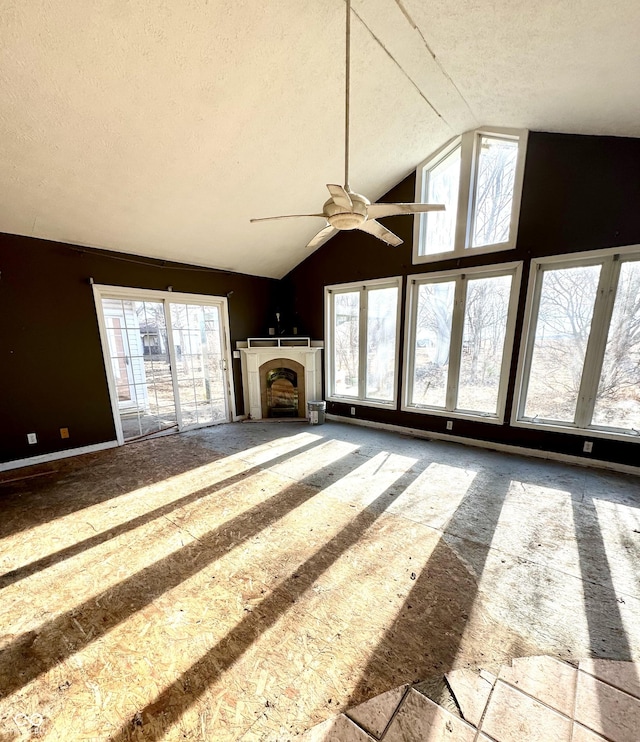 unfurnished living room with a fireplace, high vaulted ceiling, and a textured ceiling