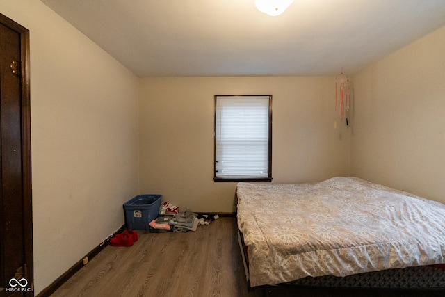 bedroom with baseboards and wood finished floors