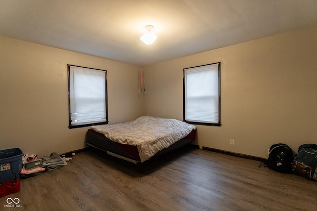 bedroom with wood finished floors and baseboards