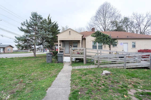 view of front of property featuring a deck, a front yard, and a chimney