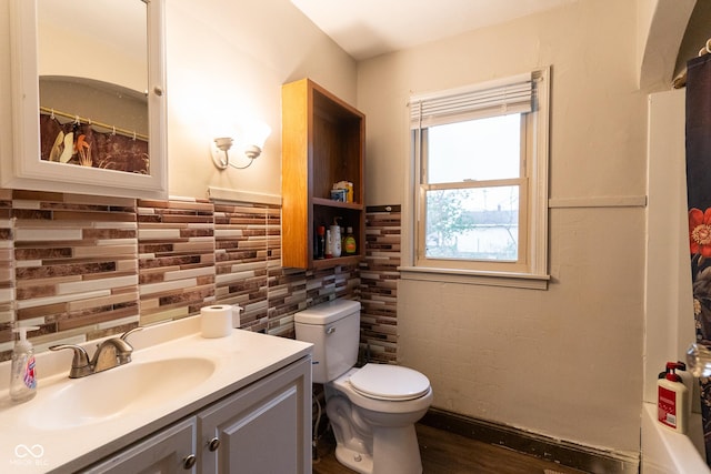 bathroom with toilet, a shower with curtain, tile walls, and vanity