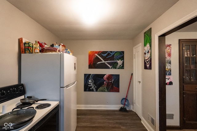 kitchen with electric range oven, dark wood finished floors, visible vents, and baseboards