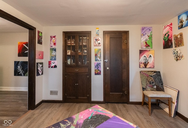 interior space featuring baseboards, visible vents, and wood finished floors