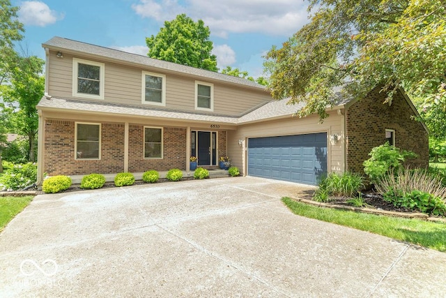 6530 Grant Wood Ct, Indianapolis, IN 46256 - traditional home with a garage, driveway, brick siding, and a shingled roof