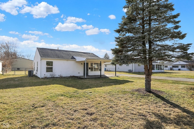 view of front of home featuring central air condition unit, a patio area, fence, and a front lawn