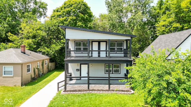 view of front facade featuring a porch, a front yard, and a balcony