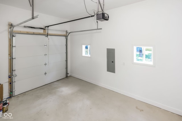 garage featuring a garage door opener, electric panel, and baseboards