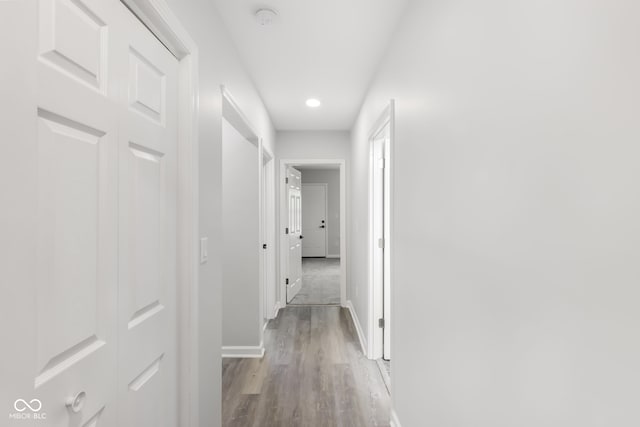 hall with baseboards and wood finished floors