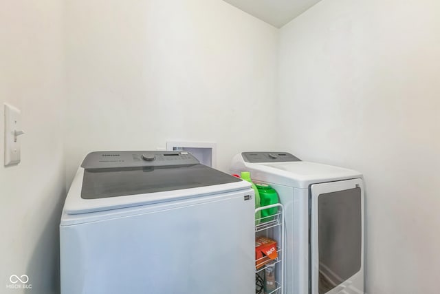clothes washing area featuring laundry area and washer and clothes dryer