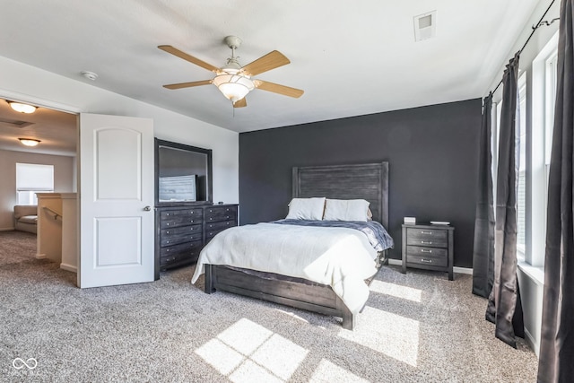 carpeted bedroom with ceiling fan, visible vents, and baseboards
