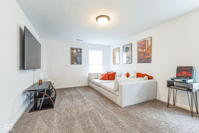 carpeted living area featuring visible vents and baseboards