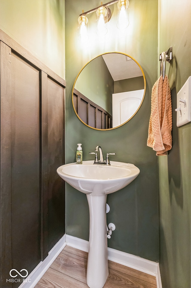 bathroom featuring a sink, wood finished floors, and baseboards