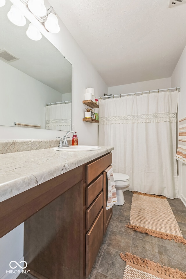 full bath featuring toilet, vanity, and visible vents