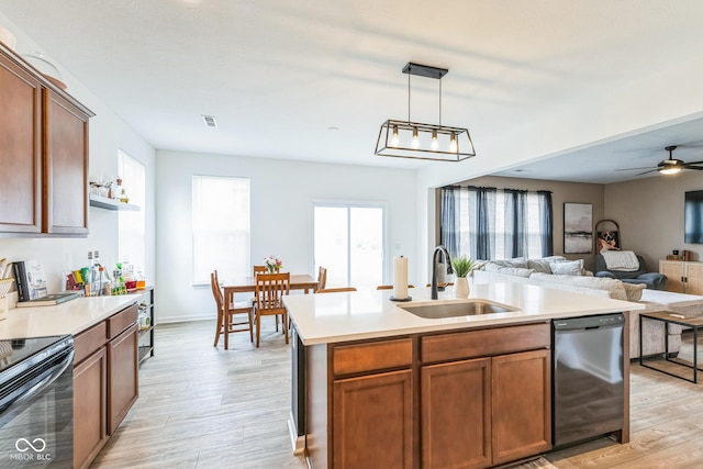 kitchen with light wood-style floors, light countertops, a sink, and dishwasher