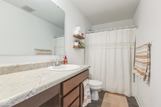 bathroom with toilet, vanity, and visible vents