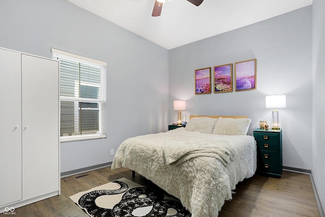 bedroom featuring a closet, visible vents, ceiling fan, wood finished floors, and baseboards