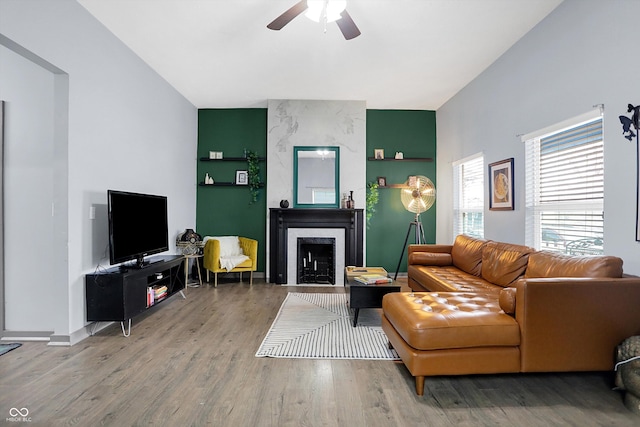 living room with a fireplace, wood finished floors, a ceiling fan, and baseboards