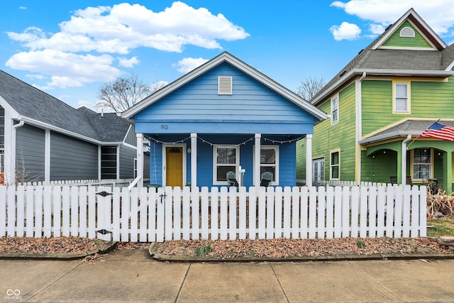 view of front of house featuring covered porch and a fenced front yard