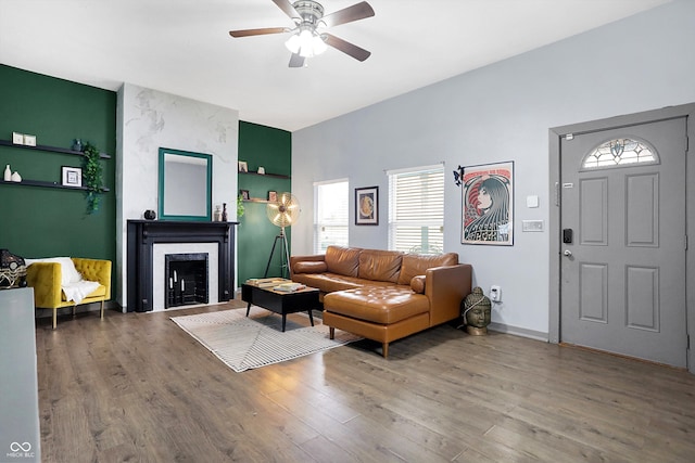 living area with a high end fireplace, a wealth of natural light, and wood finished floors