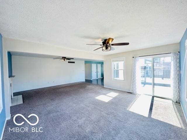 unfurnished room with a ceiling fan, carpet, a textured ceiling, and baseboards