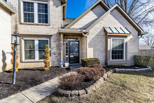 entrance to property with fence and brick siding